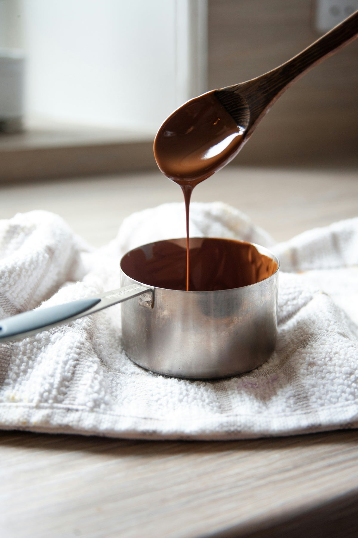 Melted chocolate pouring into a cup
